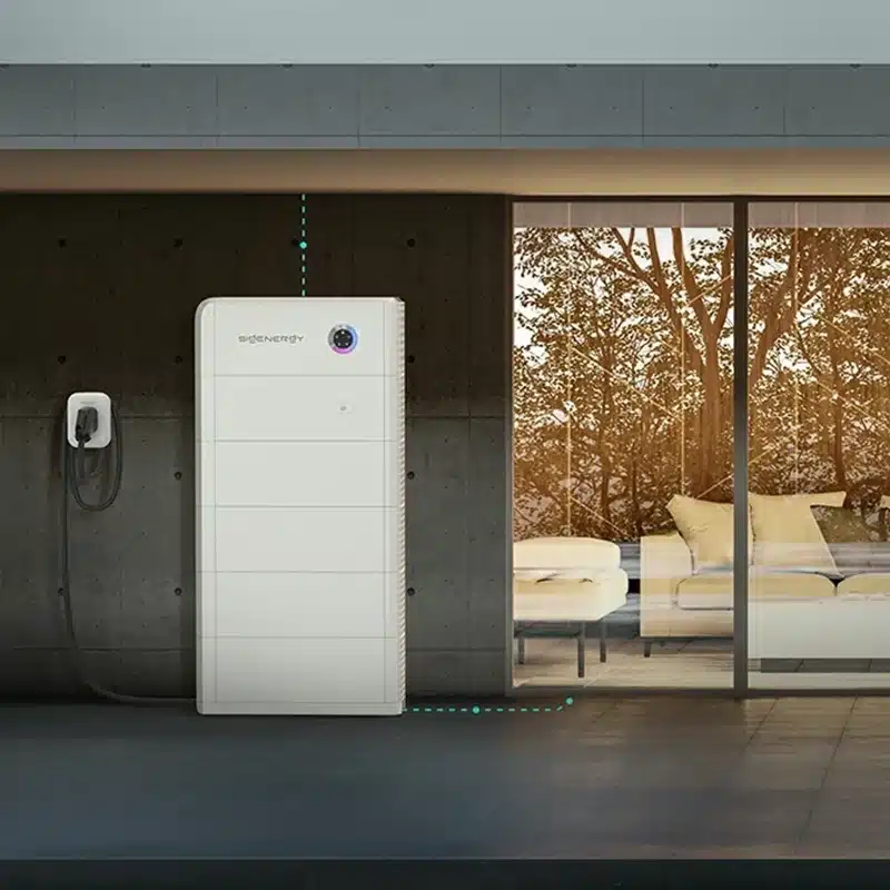 Sigenergy SigenStor — stacked white modules with a small status display against a concrete-wall outdoor space